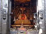 Kathmandu Patan Golden Temple 24 Shakyamuni Buddha In Main Temple An extremely ornate statue of Shakyamuni Buddha is the main image inside the main shrine of the Golden Temple in Patan. The two bells hanging from the ceiling in the front of the Buddha are used to perform daily worship.